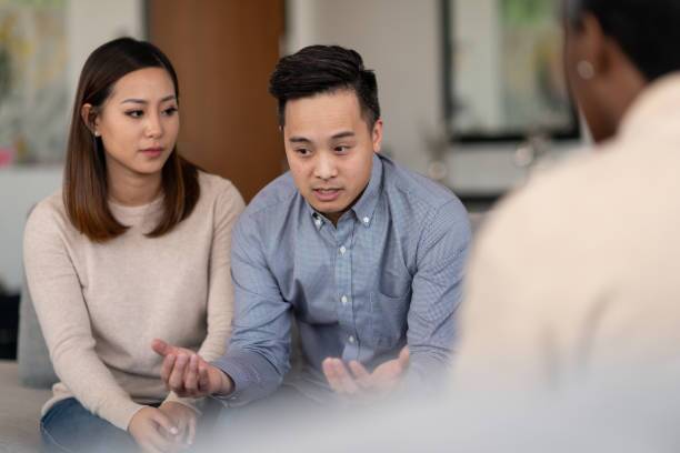 Marriage therapy An Asian married couple talks to a therapist together about their life. They are attentive and focused on making their marriage work. divorce couple stock pictures, royalty-free photos & images
