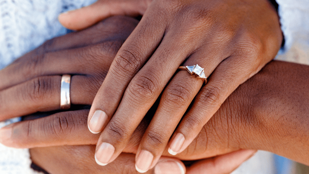 Close up of a man and woman's hands with wedding rings