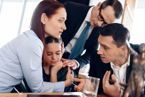 father is angry at child during custody battle, mom is hugging her child