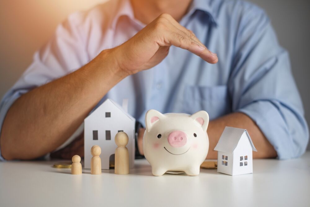 Real estate agent hands over piggy bank for protection and care. Property insurance concept. New home purchase. A loan deal for real estate, A loan agreement for real estate