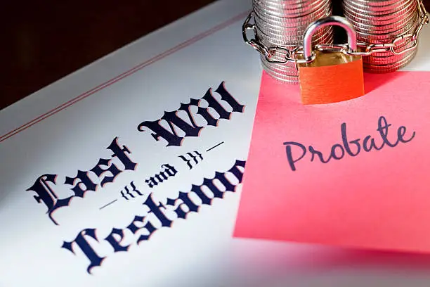 Coins chained and locked next to a sticky note that says "Probate" on top of a Last Will and Testament