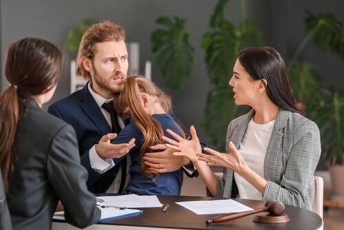 Young couple and their daughter visiting divorce lawyer in office