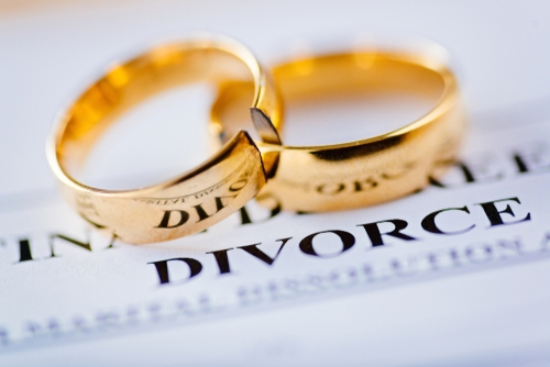 Two broken golden wedding rings divorce decree document. Divorce and separation concept, how to file for divorce in dallas county