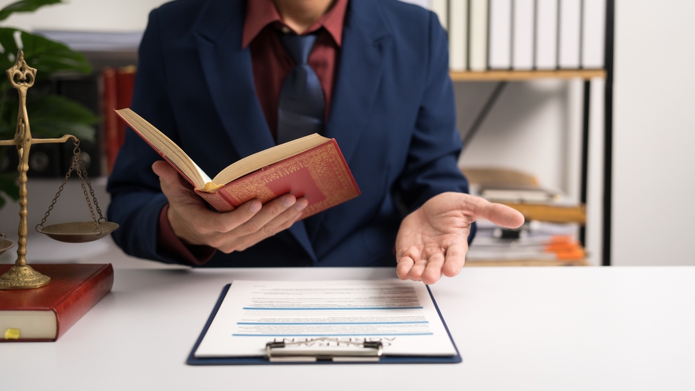 Male lawyer working with law book, A legal binding, Unilateral contract, Multilateral, Non-reciprocal contract, Default, Obligation, Power of attorney, Defense of a prescription, Court decree