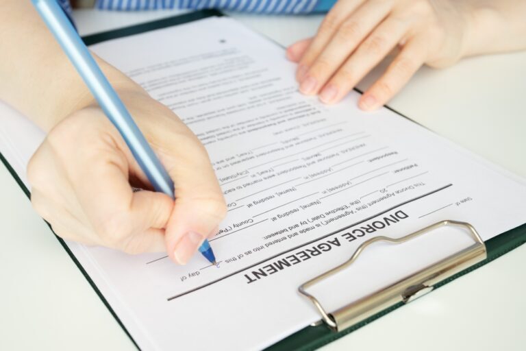 Divorce agreement, hand fills out a document, legal proceedings, signing the decree, ending the marriage
