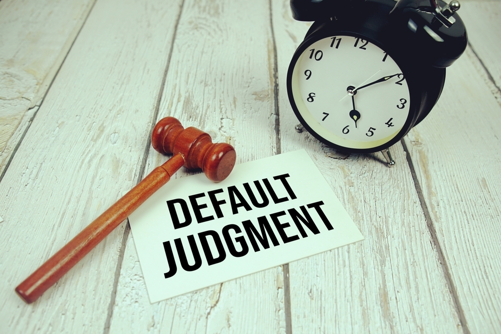 default judgment written on a note, a clock, and table
