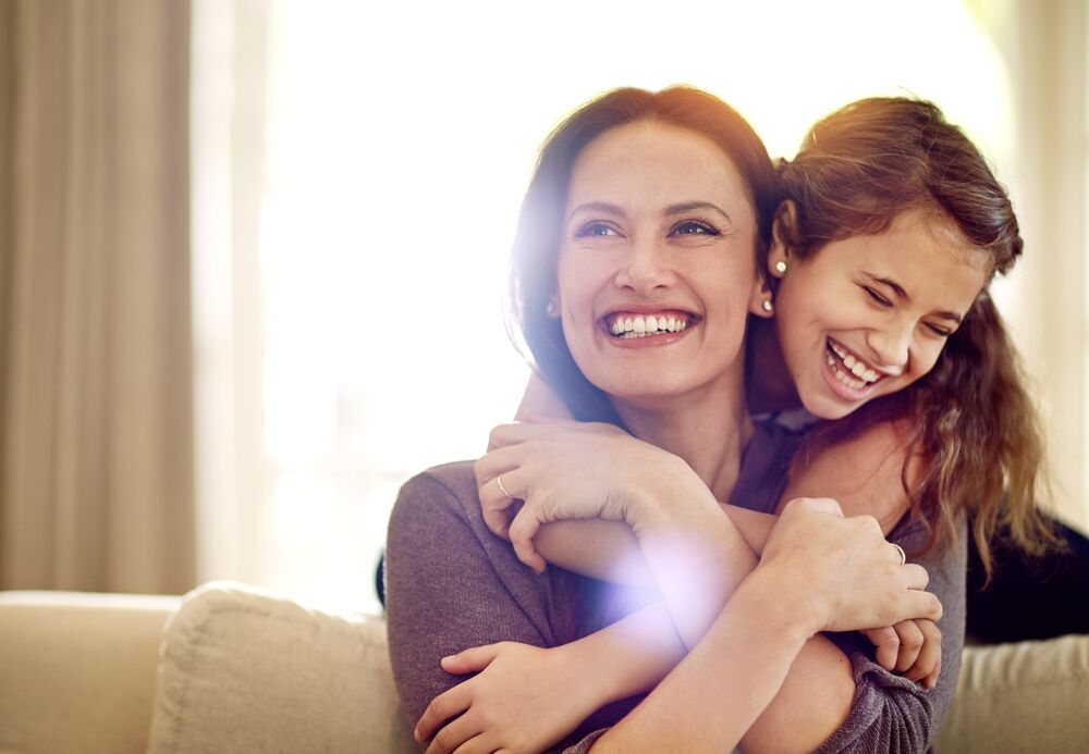 mother hugging her daughter happily
