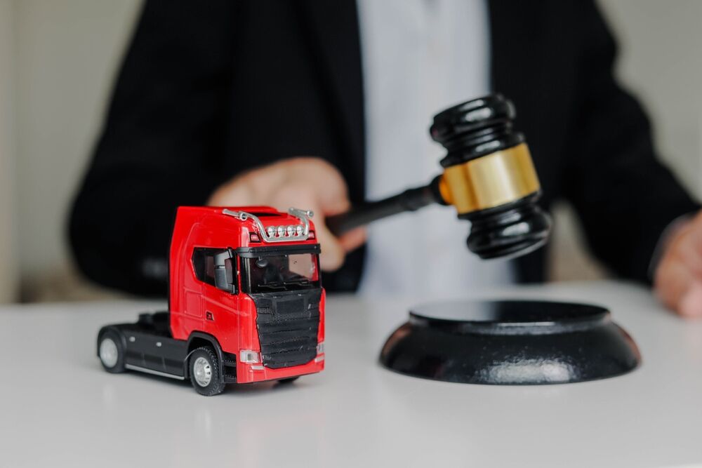 Male Judge hitting Gavel off a block in courtroom. Prohibited export concept. Toy cargo truck on the table. vehicle repossession laws in texas