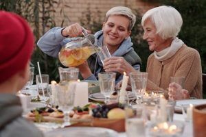 Young woman pouring a drink for an older woman