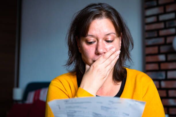 Distraught woman looking at paperwork