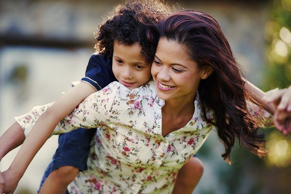 Mother smiling with child on her back