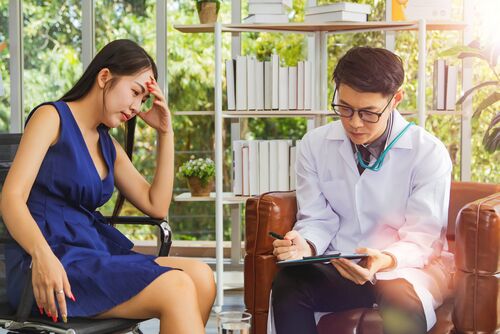 Psychologist listens to her patients and writes down notes from her : Woman, frustrated by the stress of her divorce, is consulting a psychiatrist to heal her state of mind.