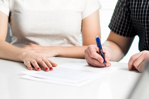 Close up of man and woman signing paperwork