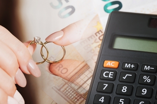 Wedding rings on money. Cost of wedding. Price of getting married background. Golden jewelry on banknote. Cash for getting divorced. Expensive marriage. Fifty euro note. Engagement money.