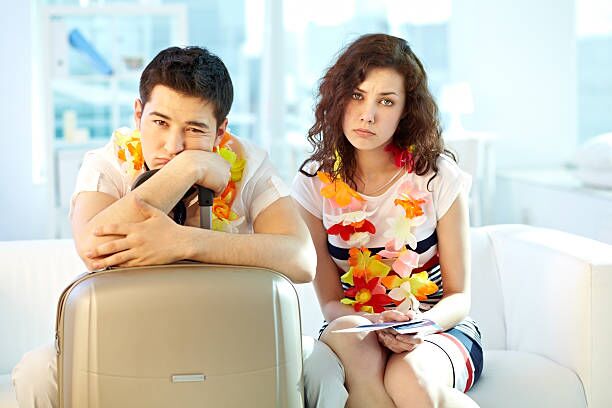 Portrait of a sad couple of travellers going to depart