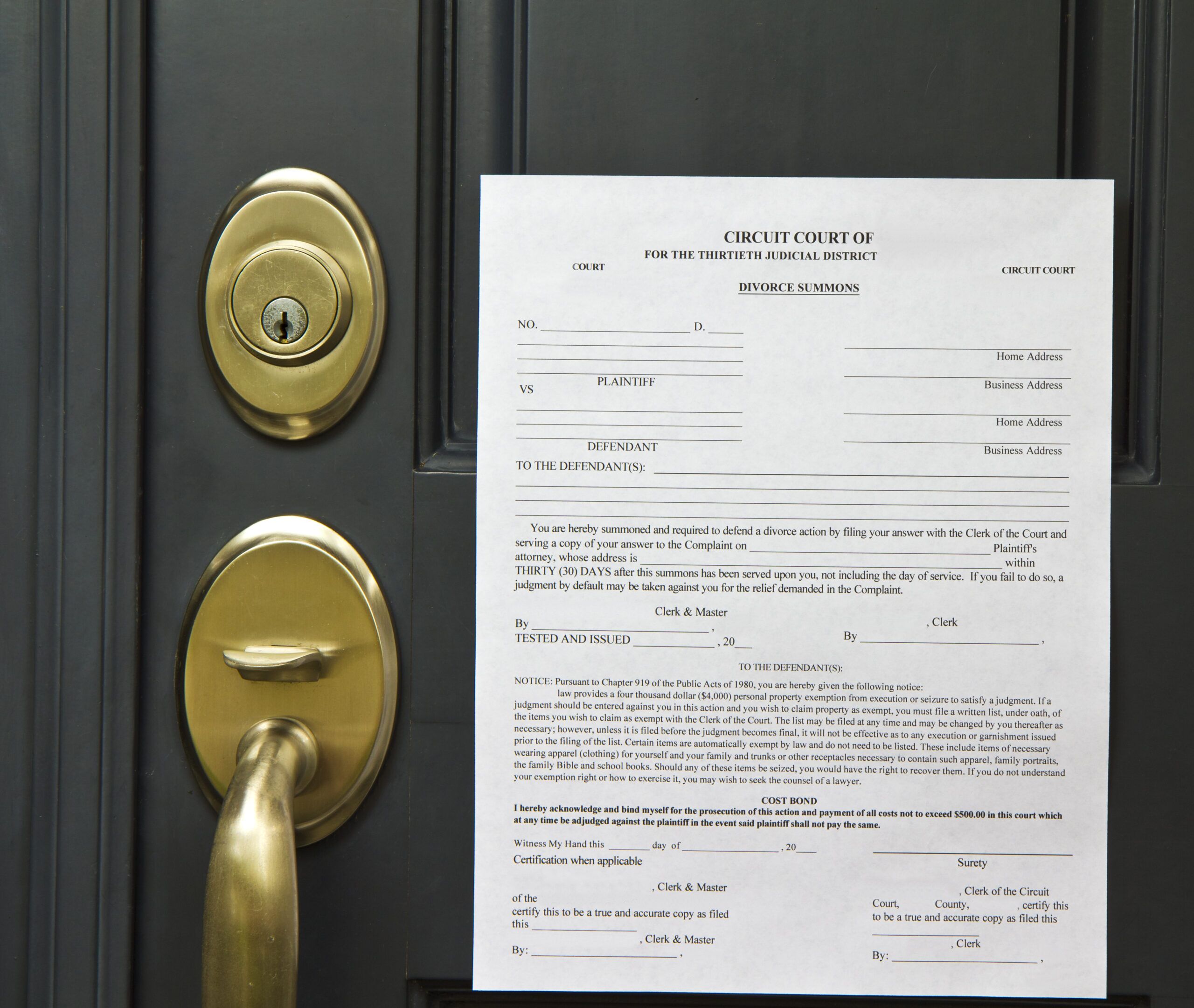 A divorce summons is taped to a gray door with a brass handle and lock.